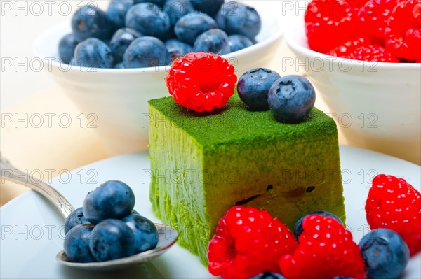 Green tea matcha mousse cake with raspberries and blueberries on top