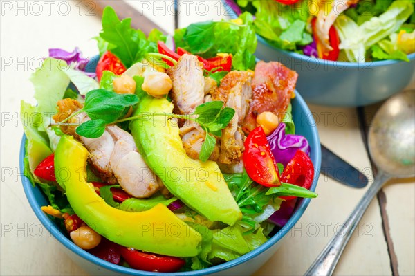 Fresh and healthy Chicken Avocado salad over rustic wood table