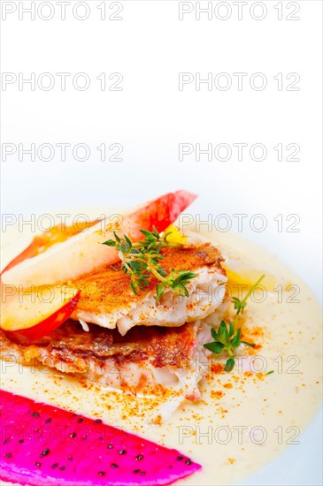 Sea bream orata fillet butter pan fried with fresh peach prune and dragonfruit slices thyme on top