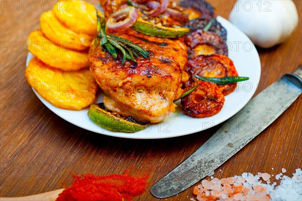 Roasted grilled BBQ chicken breast with herbs and spices rustic style