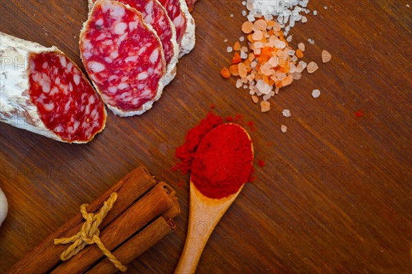 Traditional Italian salame cured sausage sliced on a wood board