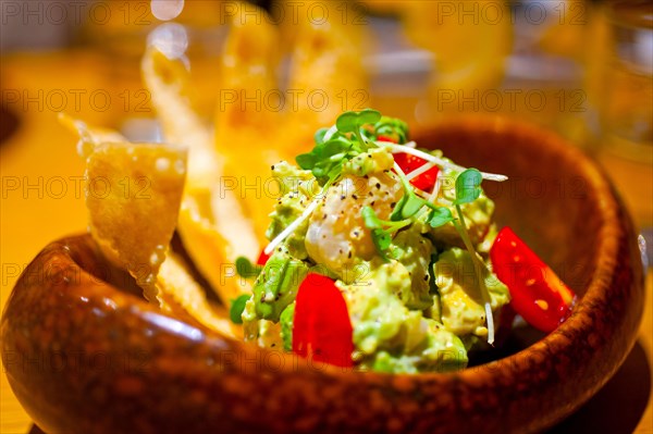 Fresh avocado and shrimps salad with nachos on side