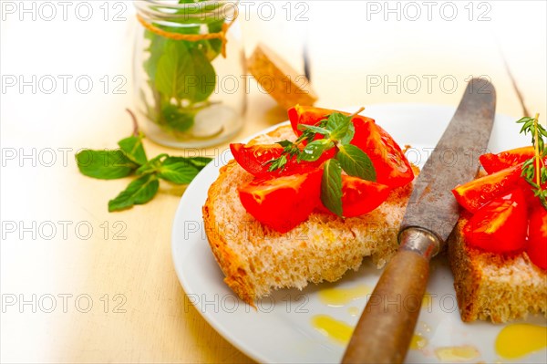 Italian tomato bruschetta with thyme and mint leaves