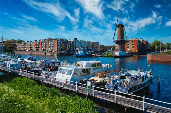 View of the harbour of Delfshaven with the old grain mill known as De Destilleerketel. Rotterdam