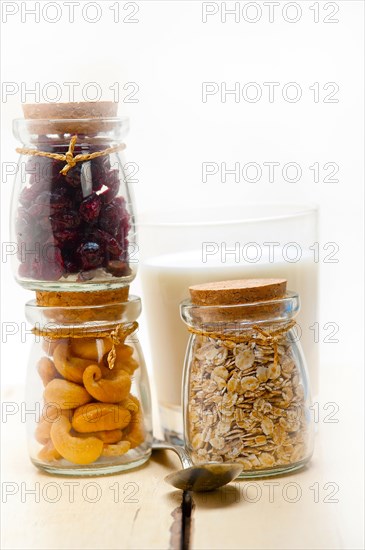 Healthy breakfast ingredients milk oat cashew nuts dried cramberry craisinns