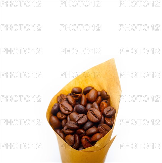 Espresso coffee beans on a paper cone cornucopia over white background