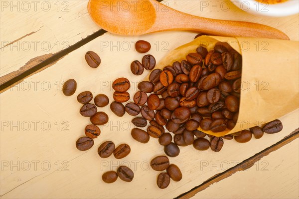 Espresso coffee and beans on a paper cone cornucopia over white background