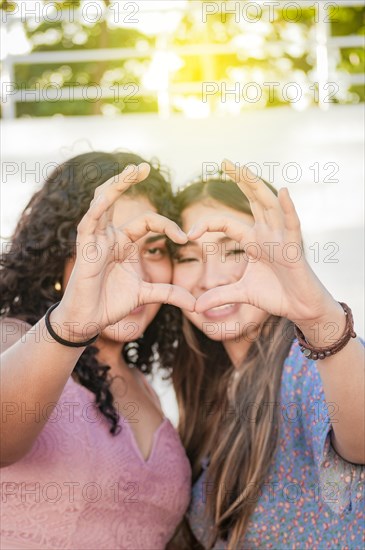 Close up of two girls making a heart shape