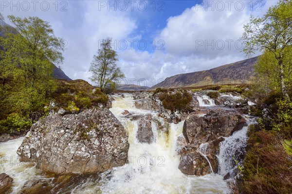 Waterfall on river Coupal and mountain range Buachaille Etive Mor