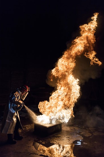 Firefighter extinguishes a heptane 2B-Pan fire with a 2-BTP extinguisher