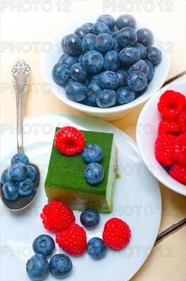 Green tea matcha mousse cake with raspberries and blueberries on top