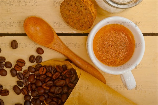 Espresso coffee and beans on a paper cone cornucopia over white background