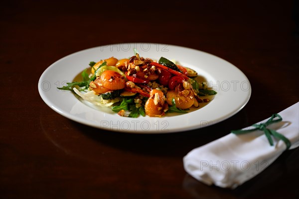 Summer salad plate with an adjacent cloth napkin on a wooden table