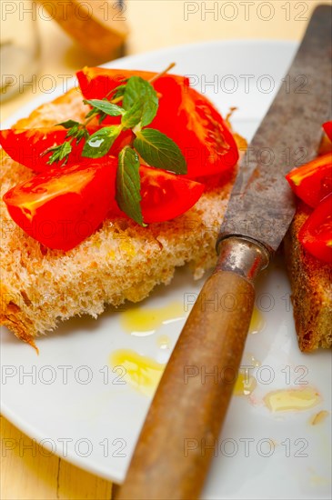 Italian tomato bruschetta with thyme and mint leaves