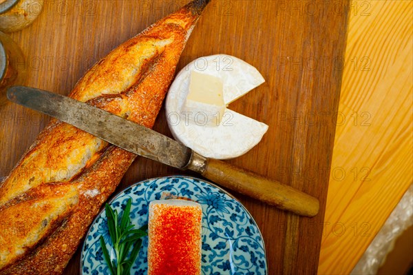 French cheese and fresh baguette on a wood cutter