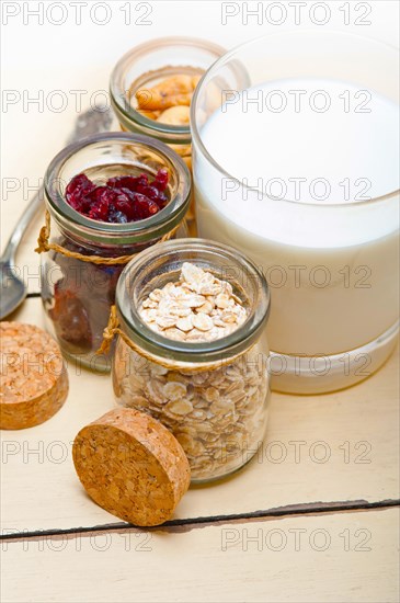 Healthy breakfast ingredients milk oat cashew nuts dried cramberry craisinns