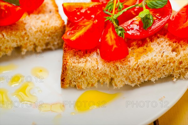 Italian tomato bruschetta with thyme and mint leaves