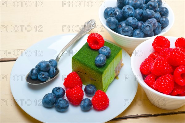 Green tea matcha mousse cake with raspberries and blueberries on top