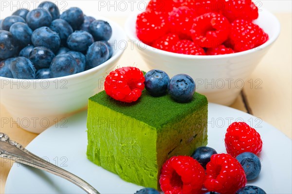 Green tea matcha mousse cake with raspberries and blueberries on top