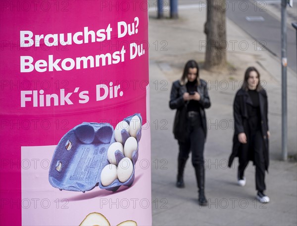 Advertisement of the delivery service Flink on an advertising pillar