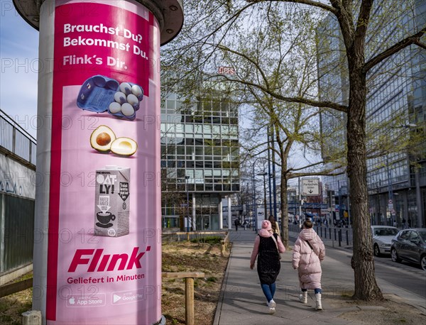 Advertisement of the delivery service Flink on an advertising pillar