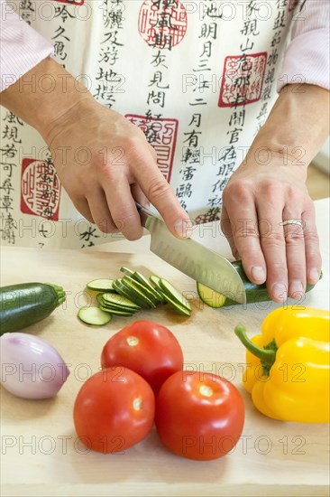 Adult male cutting various vegetables in the kitchen