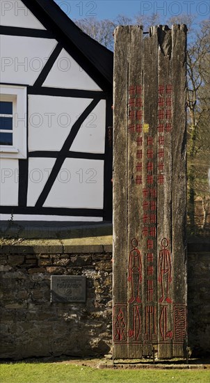 Wooden stele made of ship planks in front of half-timbered house at St. Pancratius Church on the occasion of the 1000th anniversary of the parish