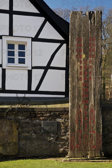 Wooden stele made of ship planks in front of half-timbered house at St. Pancratius Church on the occasion of the 1000th anniversary of the parish
