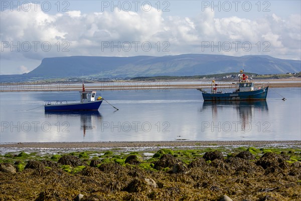 Boat in shallow water with scenic Irish view of Ben Bulben in background. County Sligo