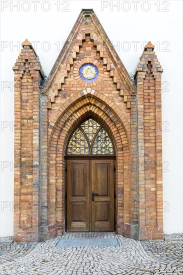 Portal at St. John's Church with the symbol of the Trinity