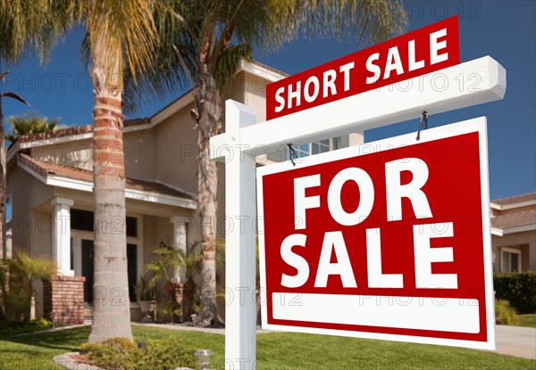 Short sale home for sale real estate sign and house