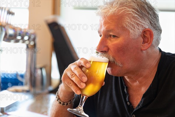 Handsome man tasting A glass of micro brew beer