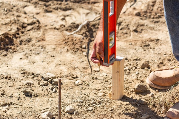 Worker using level at construction site