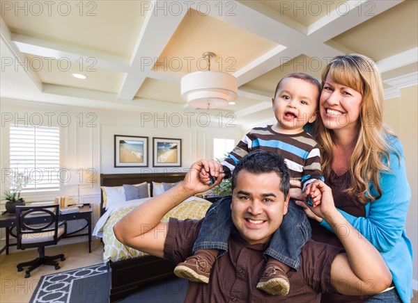 Happy mixed-race family in new custom bedroom