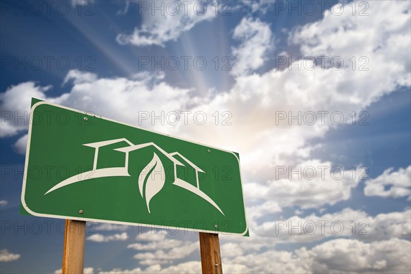 Green house design green road sign against dramatic sky