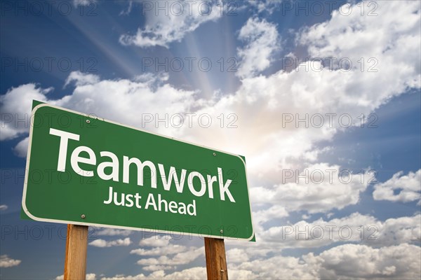 Teamwork green road sign with dramatic clouds and sky