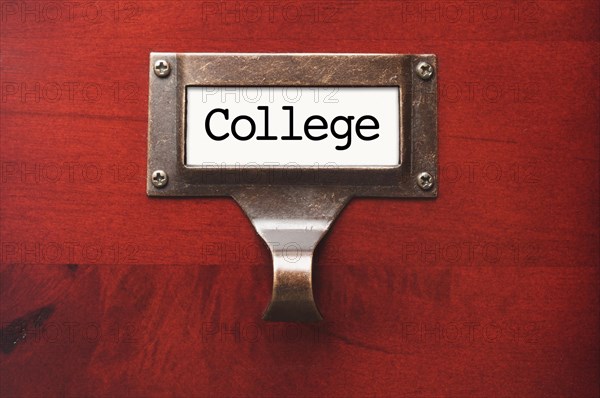 Lustrous wooden cabinet with college file label in dramatic light