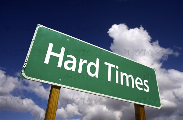 Hard times road sign with dramatic clouds and sky