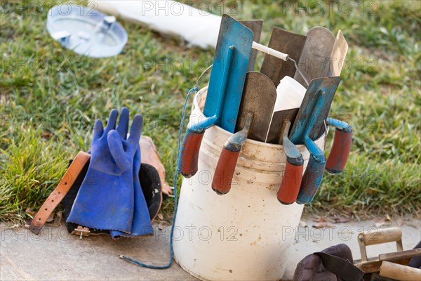 Bucket of cement trowels and tools
