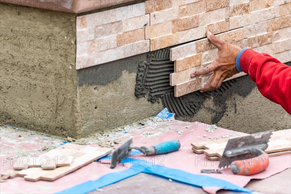 Worker installing wall tile at construction site