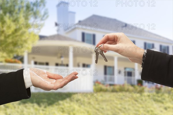 Handing over the new house keys with home in the background