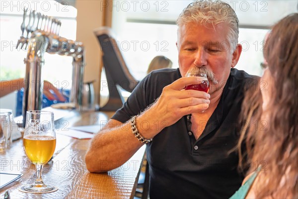 Handsome man tasting A glass of micro brew beer