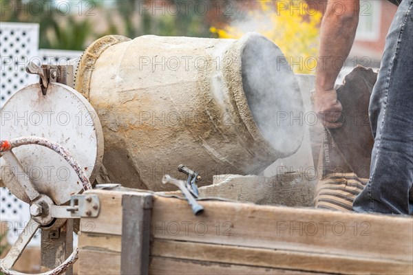 Construciton worker mixing cement at construction site