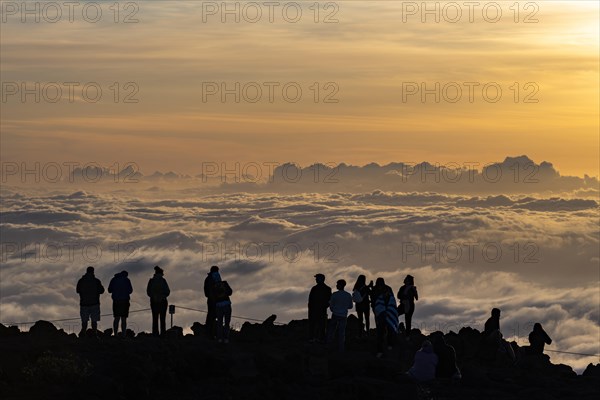 Touristen beobachten den Sonnenuntergang auf dem Gipfel des Haleakala Vulkan