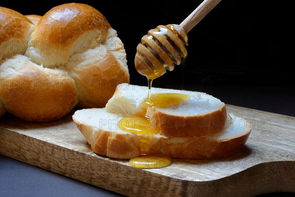 Bee honey dripping onto butter plait discs