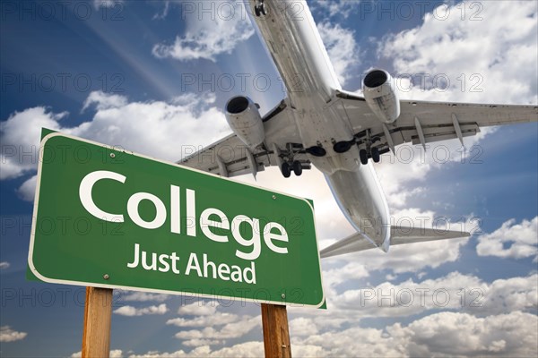 College green road sign and airplane above with dramatic blue sky and clouds