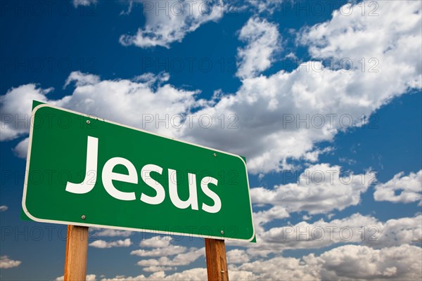 Jesus green road sign with copy room over the dramatic clouds and sky