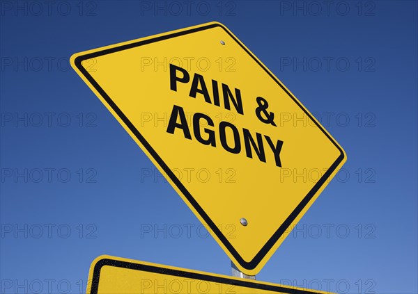 Pain and agony yellow road sign against a deep blue sky with clipping path