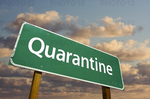 Quarantine green road sign with dramatic clouds and sky