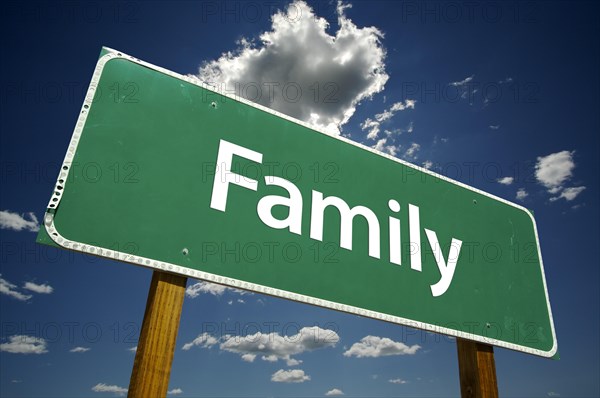 Family road sign with dramatic clouds and sky